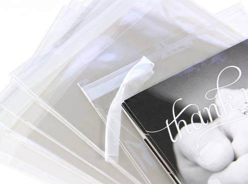 Clear bags with reusable peel and seal strip