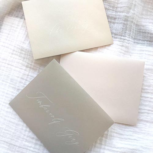 White printing on light blush, taupe and gray envelopes. White printing and addressing by LCI Paper